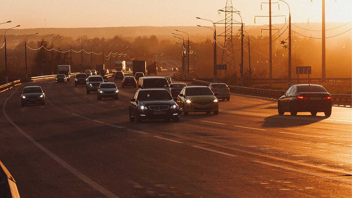 cars drive while it's sunset