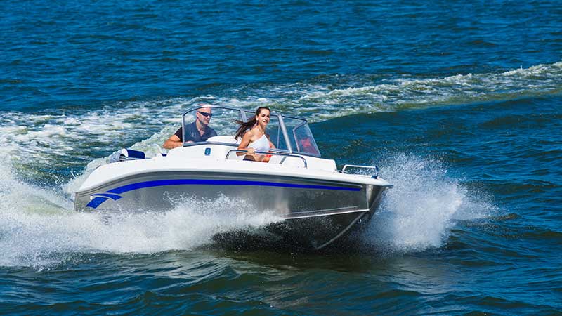 a couple ride a fast boat on calm waters