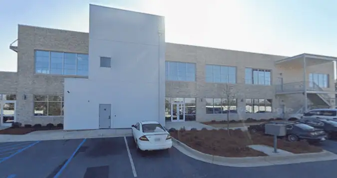 Two-story office building for Peachy Insurance at 5547 Veterans Parkway in Columbus, Georgia, with parked cars and accessible parking spaces in front.