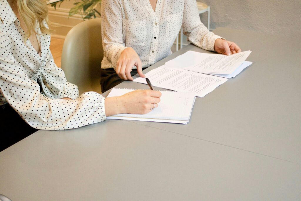 Landlord and tenant reviewing a rental lease agreement that includes a renters insurance requirement and proof of coverage.
