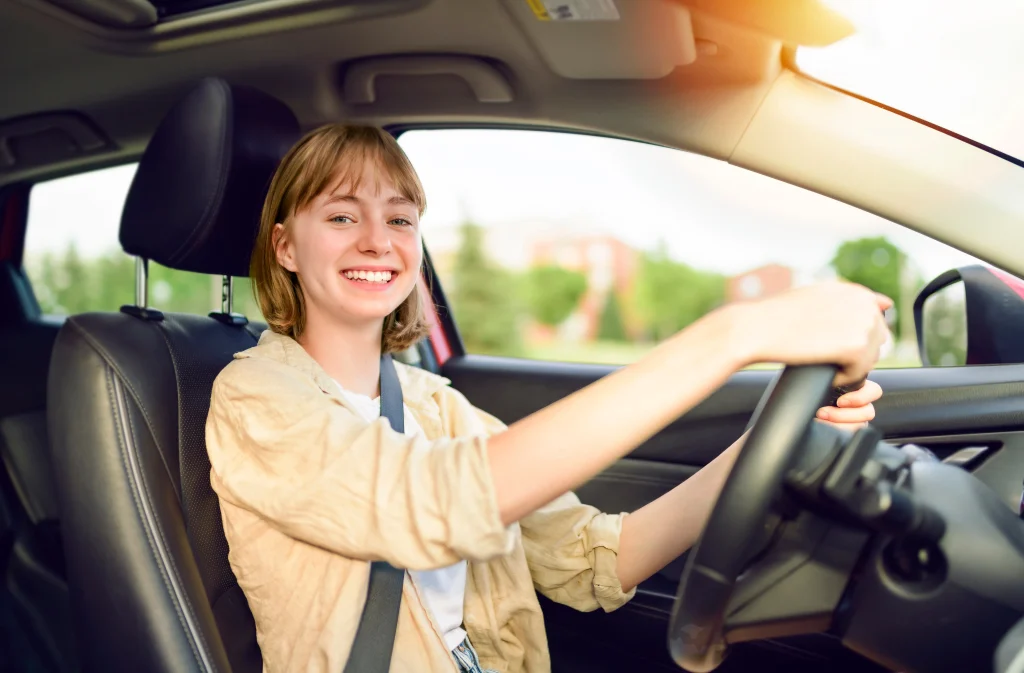 Teen driver getting ready to drive a family car, illustrating the higher insurance costs associated with adding a young driver to a policy.